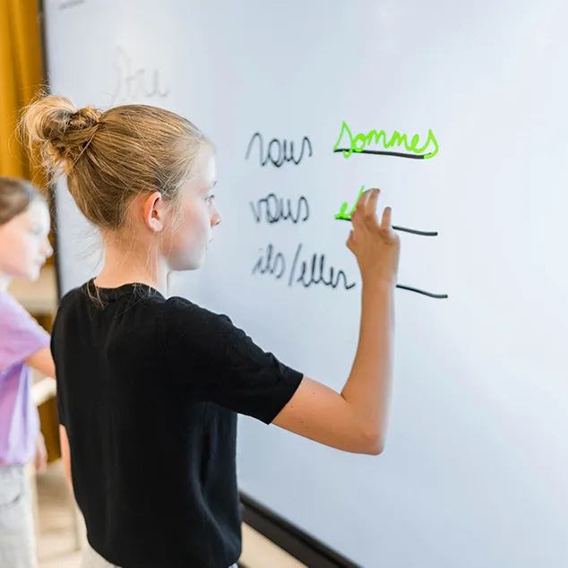 Student writing on an interactive display